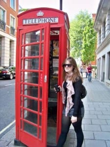 Jessica Crighton in London, England standing next to phone booth